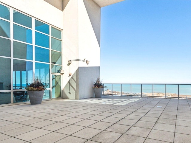 view of patio / terrace with a water view and a view of the beach