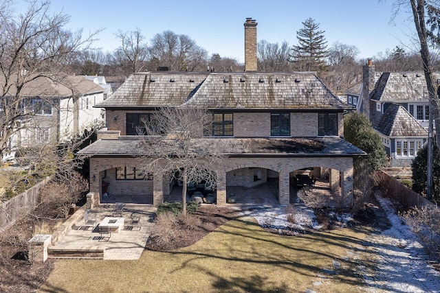 back of house with a fenced backyard, a yard, brick siding, and a patio