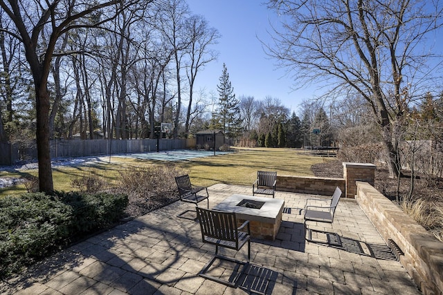 view of patio featuring an outdoor fire pit, an outdoor structure, and fence