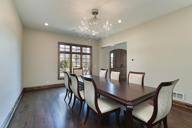 dining room with an inviting chandelier, baseboards, visible vents, and dark wood-style flooring