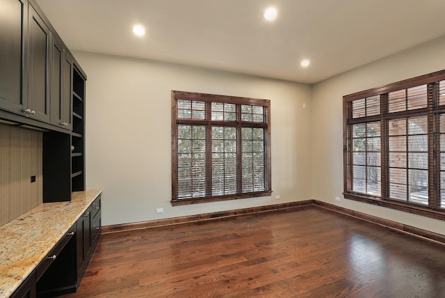 unfurnished dining area with recessed lighting, baseboards, and dark wood-style flooring