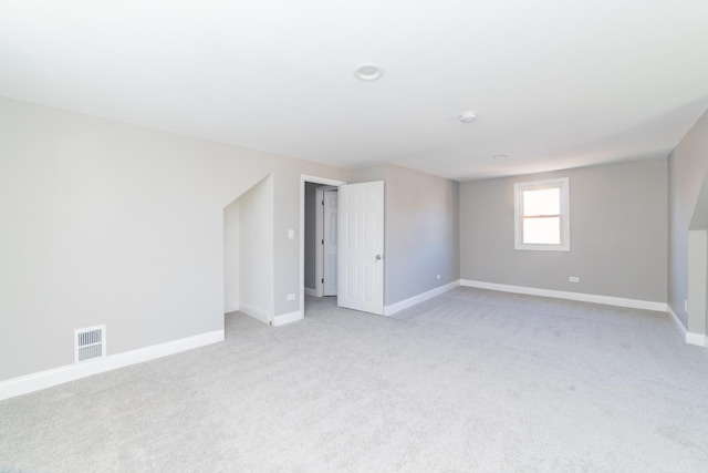 empty room with visible vents, light carpet, and baseboards