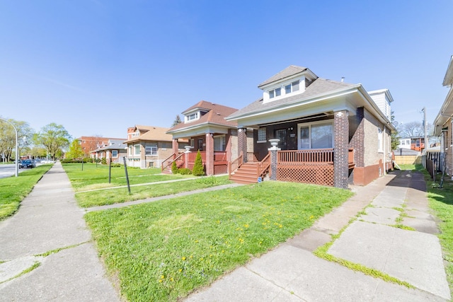 bungalow-style home featuring covered porch, brick siding, and a front yard