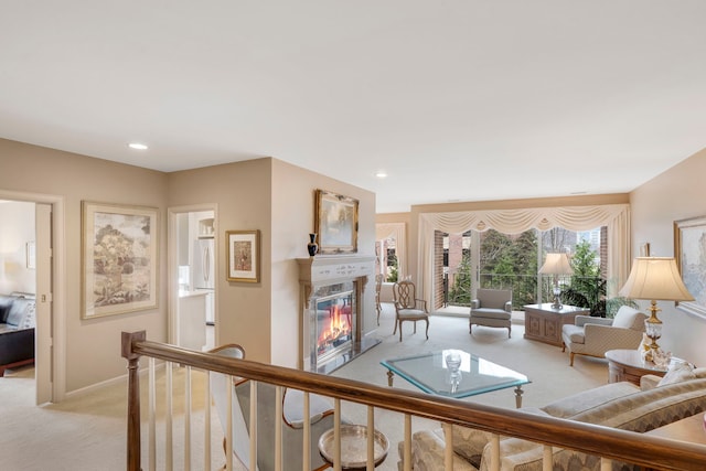 living room featuring recessed lighting, light colored carpet, baseboards, and a premium fireplace