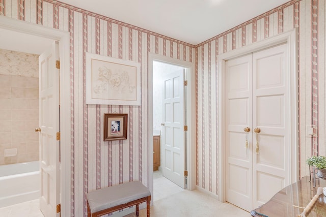 hallway with wallpapered walls and light colored carpet