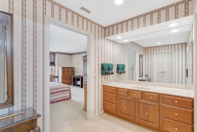 bathroom with wallpapered walls, vanity, visible vents, and connected bathroom