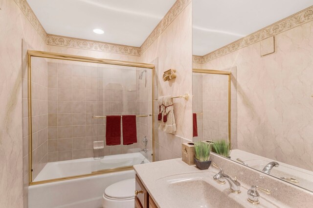 bathroom with vanity, toilet, and combined bath / shower with glass door