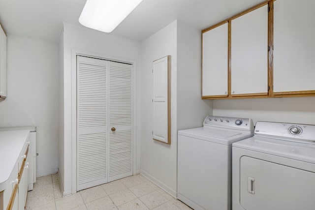 laundry room with baseboards, cabinet space, and washer and clothes dryer