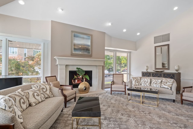 living room featuring recessed lighting, visible vents, a lit fireplace, and vaulted ceiling