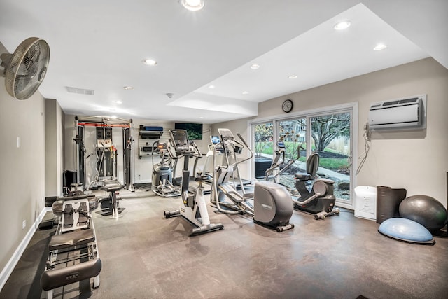 exercise room featuring visible vents, recessed lighting, baseboards, and a wall unit AC