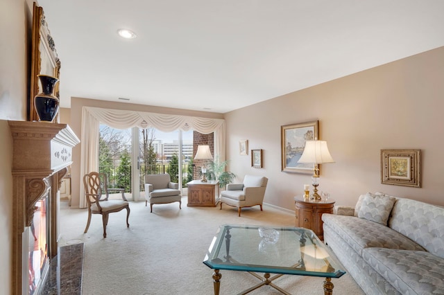 living area with a glass covered fireplace, carpet flooring, and baseboards