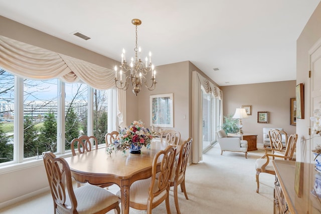 dining room featuring light colored carpet, visible vents, a chandelier, and a healthy amount of sunlight