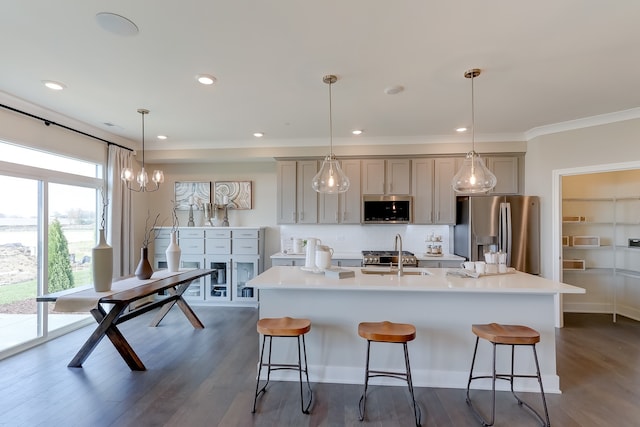 kitchen with stainless steel appliances, a sink, backsplash, and a kitchen bar