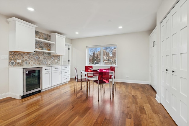 dining area featuring wine cooler, recessed lighting, and light wood finished floors