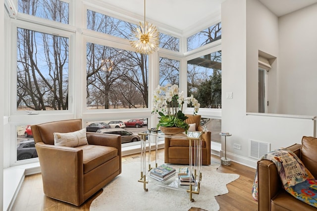 sunroom / solarium featuring an inviting chandelier and visible vents