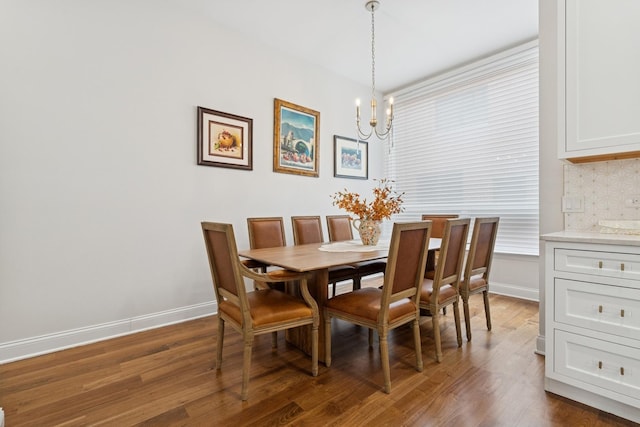 dining room with an inviting chandelier, baseboards, and dark wood-style flooring