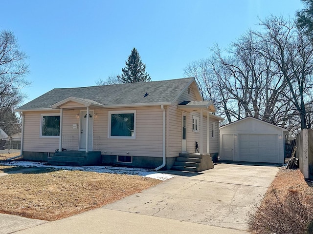 view of front of property featuring concrete driveway, roof with shingles, an outdoor structure, and a detached garage