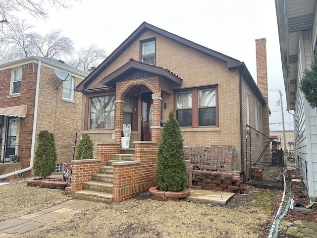 view of front of property featuring brick siding and a chimney