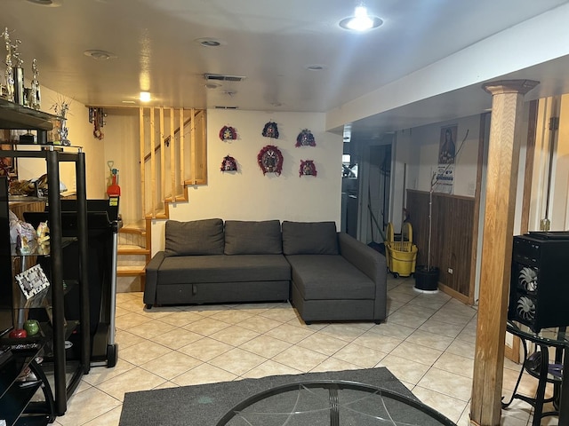 living area featuring a wainscoted wall, stairway, and light tile patterned floors