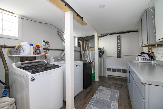 laundry area featuring radiator, electric panel, cabinet space, dark wood-style flooring, and washing machine and dryer