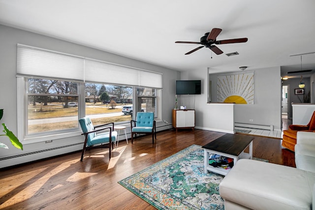 living area featuring a ceiling fan, wood finished floors, visible vents, and a baseboard radiator