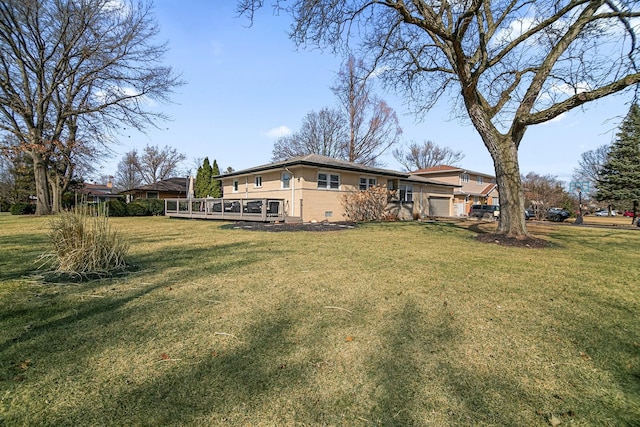 view of yard featuring an attached garage and a wooden deck