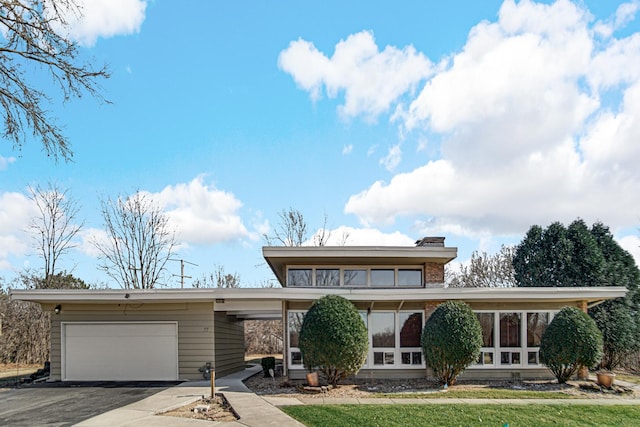 mid-century modern home featuring driveway and an attached garage