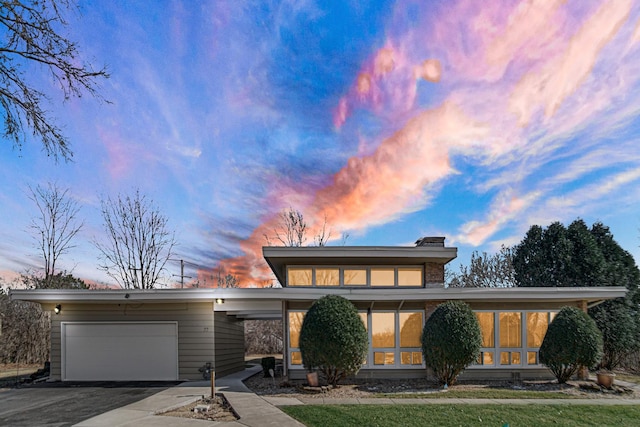 view of front of home featuring a garage and aphalt driveway