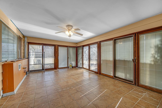 unfurnished sunroom with a ceiling fan