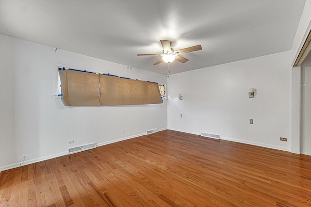 unfurnished room with a ceiling fan, baseboards, visible vents, and wood finished floors