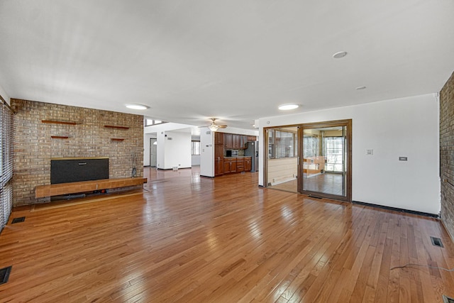 unfurnished living room with light wood-type flooring, ceiling fan, and visible vents