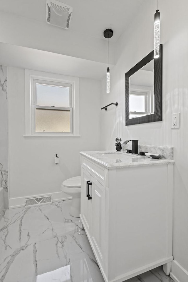 bathroom with toilet, marble finish floor, visible vents, and baseboards