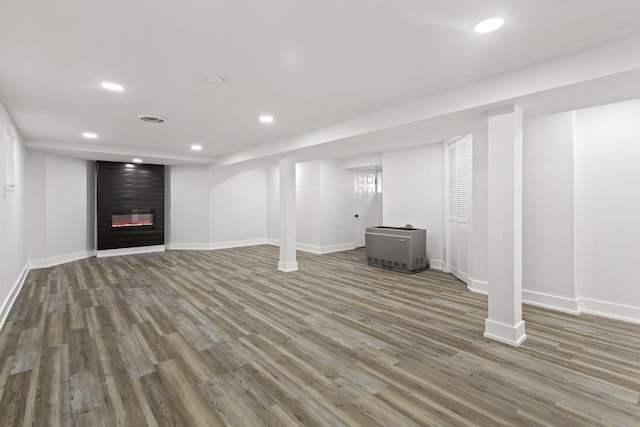 finished below grade area featuring baseboards, a fireplace, wood finished floors, and recessed lighting