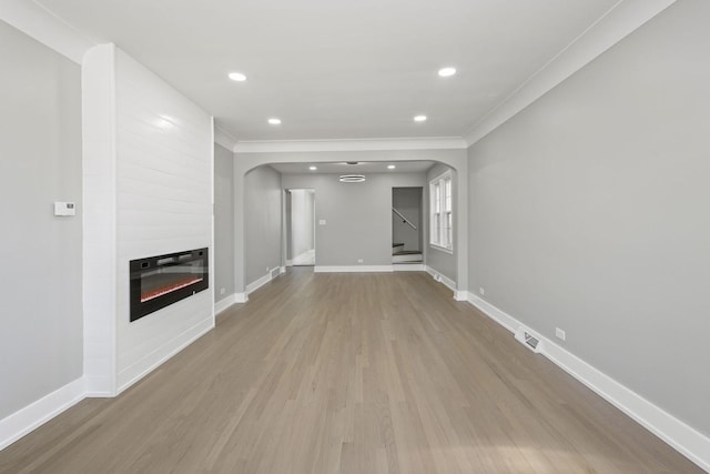 unfurnished living room featuring stairs, a fireplace, baseboards, and wood finished floors