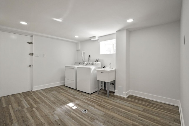 laundry area featuring washer and dryer, laundry area, baseboards, and wood finished floors