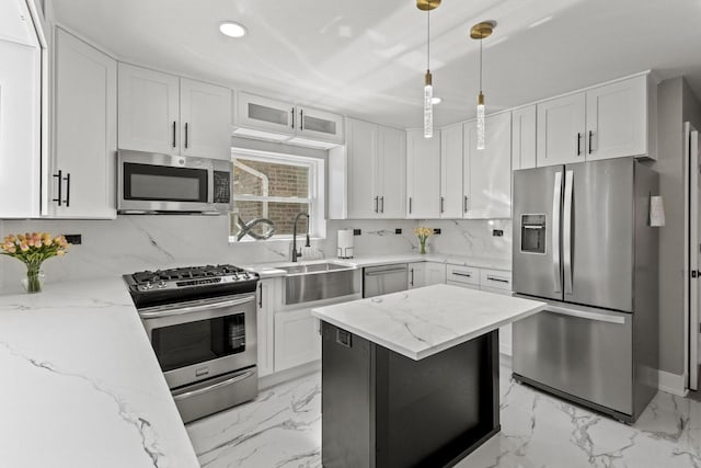 kitchen featuring marble finish floor, tasteful backsplash, appliances with stainless steel finishes, white cabinets, and a sink