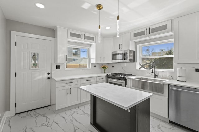 kitchen with backsplash, marble finish floor, stainless steel appliances, light countertops, and a sink