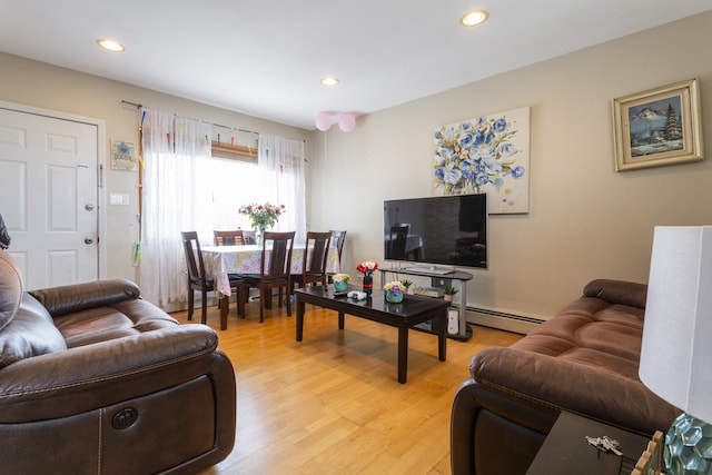 living room with a baseboard heating unit, recessed lighting, and light wood finished floors