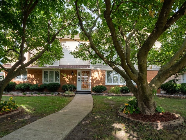 view of front of home with brick siding and a front lawn