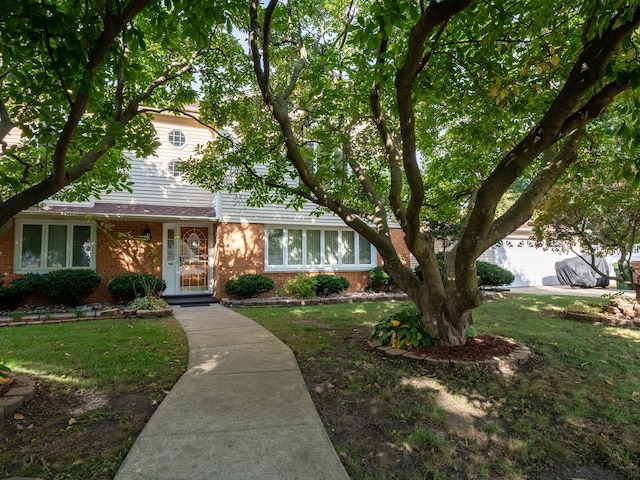 view of front of house with brick siding and a front lawn