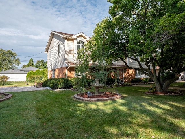 view of front of home featuring a front lawn and brick siding