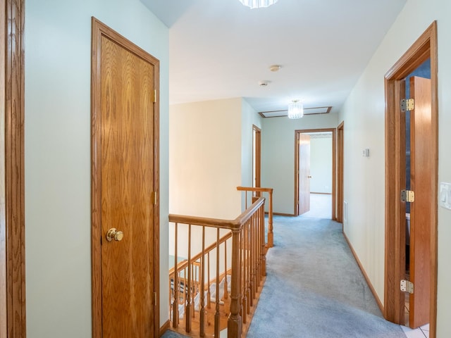 corridor featuring baseboards, light carpet, and an upstairs landing