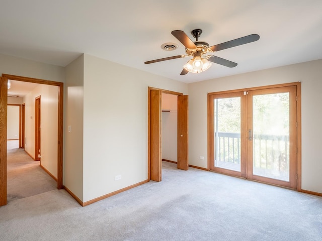 spare room with light carpet, visible vents, baseboards, and a ceiling fan