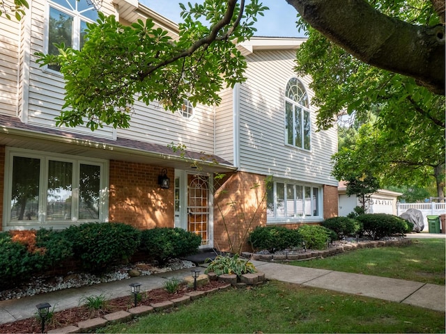 view of front of house featuring brick siding and fence