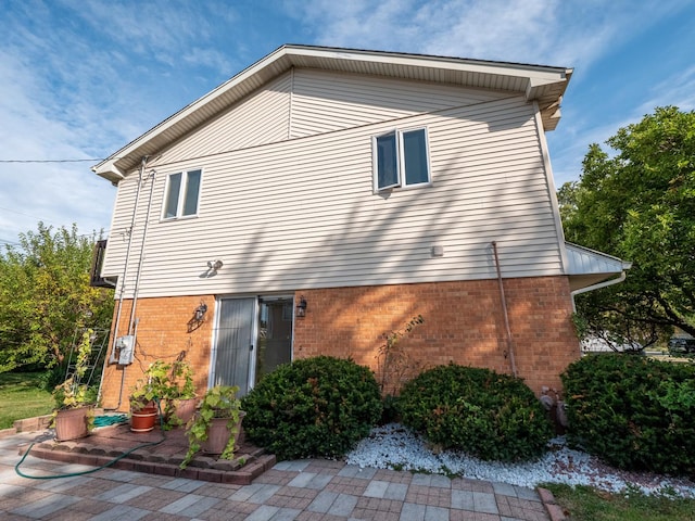 exterior space featuring a patio area and brick siding