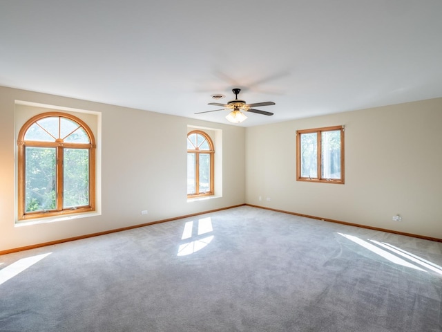 spare room with ceiling fan, baseboards, and carpet flooring