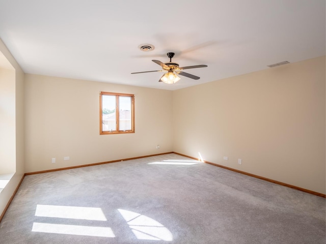 spare room featuring baseboards, carpet, visible vents, and a ceiling fan