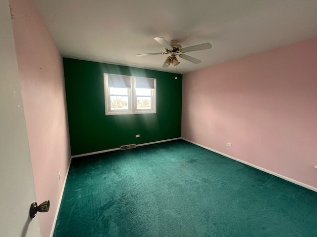 empty room featuring baseboards, carpet, visible vents, and a ceiling fan