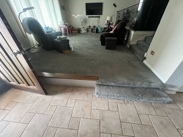 carpeted living area featuring stairs