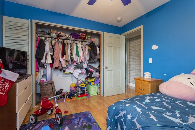 bedroom featuring ceiling fan, a closet, and wood finished floors